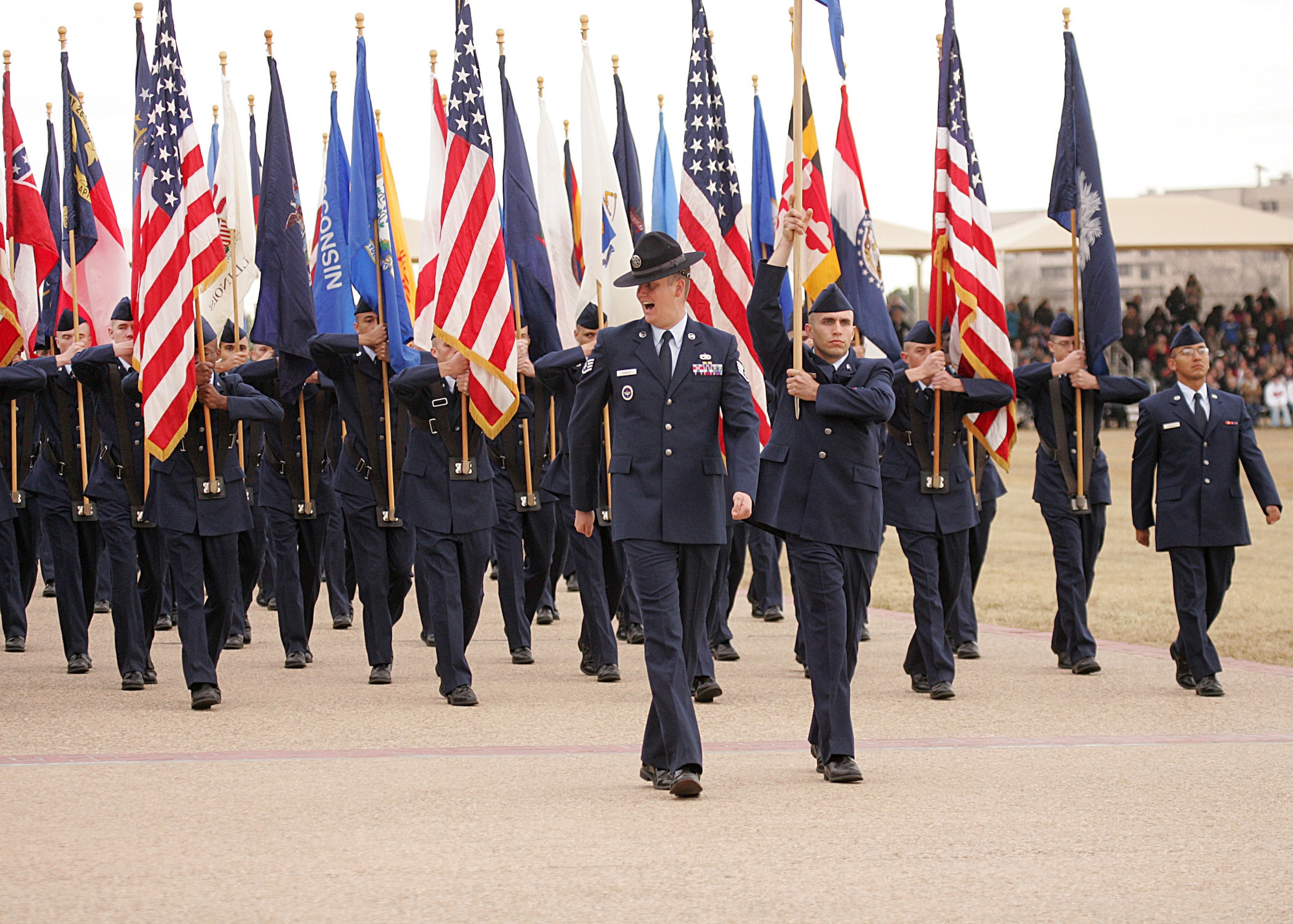 Staff Sgt. Kenneth Dancer, a military training instructor with the 321st Training Squadron, leads a group of Air Force basic military trainees carrying state flags during the BMT graduation ceremony at Lackland Air Force Base Jan. 7. MTIs mold recruits through an eight-and-a-half week BMT program focusing on basic war skills, military bearing, discipline, physical fitness, drill and ceremonies and Air Force core values. (U.S. Air Force photo/Robbin Cresswell)