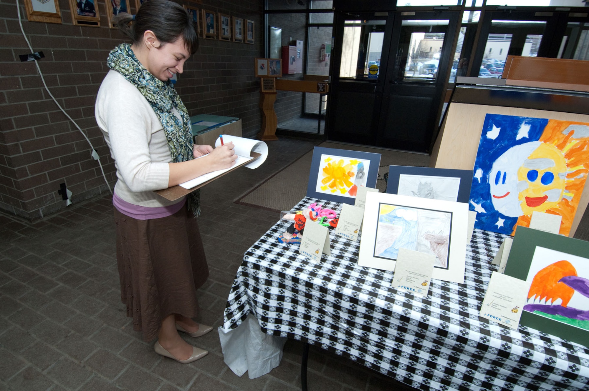 HANSCOM AIR FORCE BASE, Mass. - Nikki Cucchiara, a graphic illustrator for the 66th Force Support Squadron, judges fine art pieces in the Brown Building on Jan. 5. Children from the Youth Center and School Age programs submitted 42 art entries for the Boys and Girls Club of America National Fine Arts Exhibit Program. Thirteen entries were chosen to compete at the regional level. The artwork will be on display at the Minuteman Club through next week. (U.S. Air Force photo by Rick Berry)
