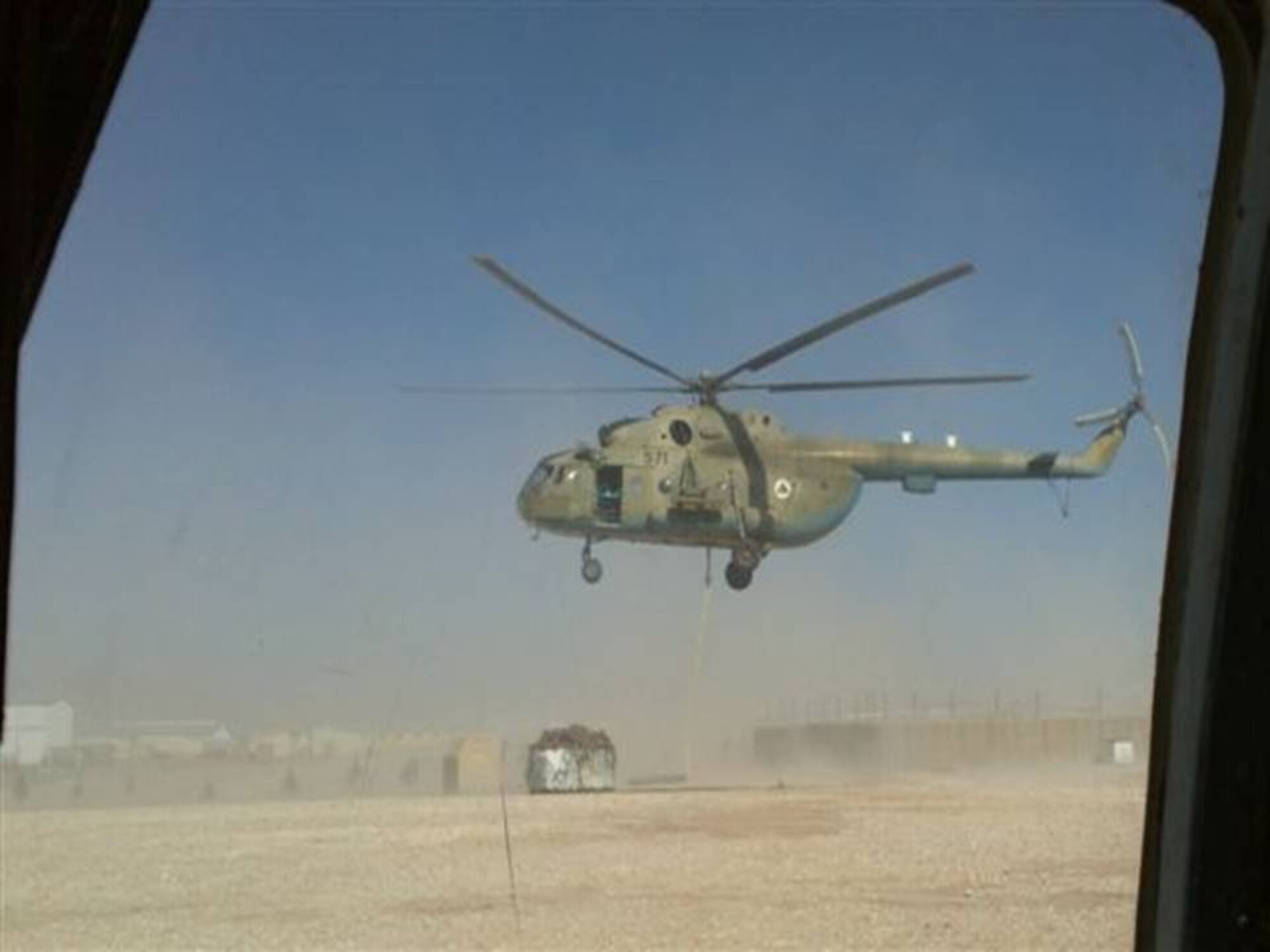 QALAT, Afghanistan -  An Afghan Air Force Mi-17 transport helicopter hovers as it picks up a sling load at Eagle LZ in Qalat. The first flight took 30 minutes at 9000 feet above sea level.  (U.S. Air Force photo/RELEASED).
