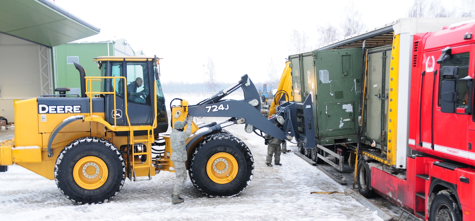 LITHUANIA AIR FORCE AIR BASE, Lithuania - Senior Airman Grant Cairel, a transportation management journeyman with the 493rd Expeditionary Fighter Squadron Redeployment Action Team, uses a forklift to load a container onto a trailer while being guided by Senior Airman Scott Knight, an air transportation journeyman with the 493rd EFS RAT, Jan. 7. Airmen Cairel and Knight are deployed from the 48th Logistics Readiness Squadron as a part of the RAT and will redeploy the 493rd EFS from Lithuania to RAF Lakenheath, England. (U.S. Air Force photo/Staff Sgt. Stephen Linch)