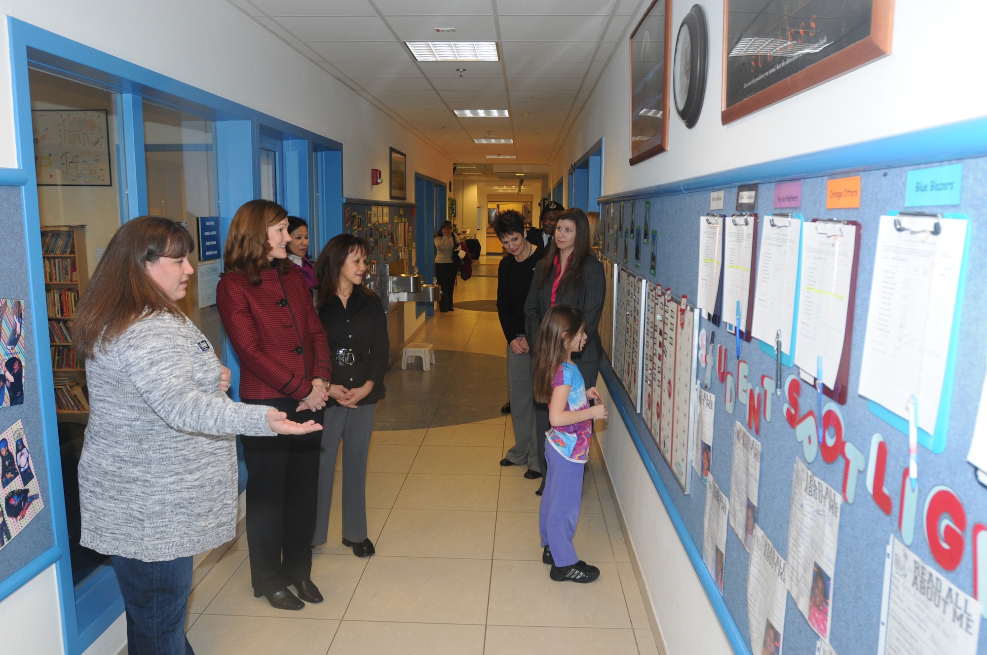 Tasia Ellison, 31st Force Support Squadron youth center staff member (left), Betty Welsh (second to left), wife of Gen. Mark A. Welsh III, U.S. Air Forces in Europe commander, and Mary Williamson (third from left), wife of Chief Master Sgt. David W. Williamson, USAFE command chief, tour the Aviano Youth Center as Mira Miller, a youth center member, looks a the School?s Age Choice programs chart Jan 10.  During the tour, Mrs. Welsh and Mrs. Williamson were shown how the youth center promotes healthy lifestyles and activities through different programs in the center. (U.S. Air Force photo/Airman 1st Class LaVel Sterling)