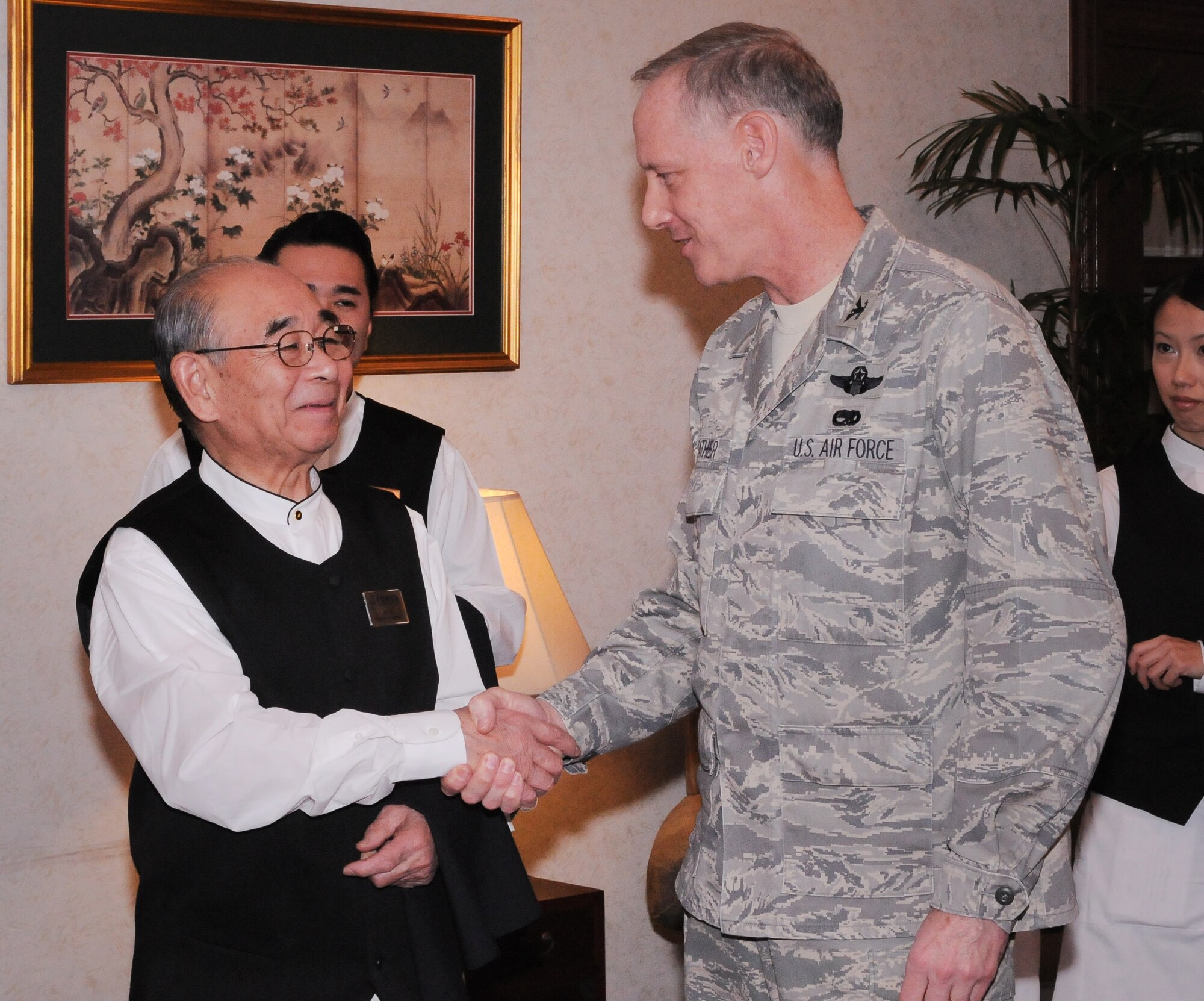 YOKOTA AIR BASE, Japan -- Col. Otto Feather, 374th Airlift Wing commander, presents Mr. Masayuki Nakamura, better known as Chico, with his commander's coin during a ribbon cutting ceremony at the Officer's Club here Jan. 12. The ceremony was held to open the brand new Chico's Chop House and Seafood Grill named in honor of Mr. Nakamura's nearly 60 years of dedicated service to those who serve. (U.S. Air Force photo/ Airman 1st Class Katrina R. Menchaca)