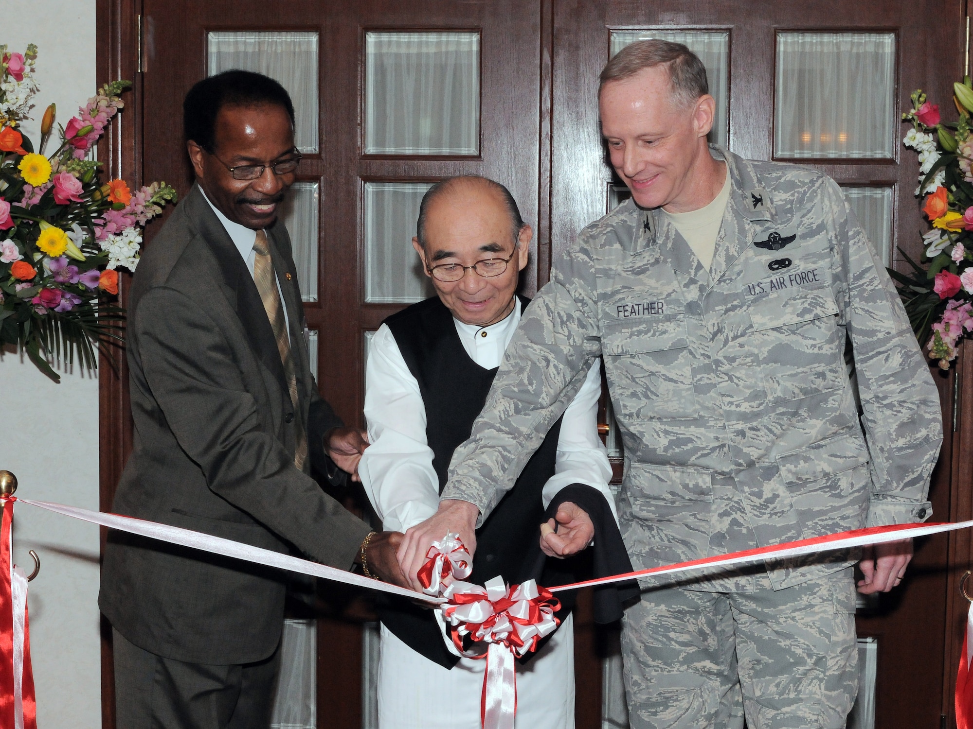 YOKOTA AIR BASE, Japan -- Col. Otto Feather, 374th Airlift Wing commander (right) along with  Mr. Masayuki "Chico" Nakamura (center) and Mr. Ted Watson, Officer's Club manager, cut the grand opening ribbon for  the brand new Chico's Chop House and Seafood Grill, here Jan. 12. The restaurant was named after Chico in honor of his nearly 60 years of dedicated service to those who serve. (U.S. Air Force photo/ Airman 1st Class Katrina R. Menchaca)