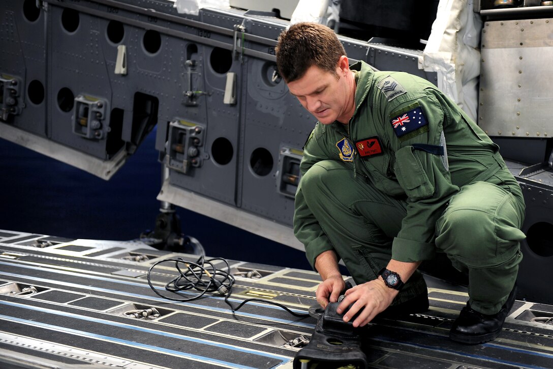 Royal Australian Air Force Flight Sgt. Dave Pyatt prepares tie downs for the container delivery system on Joint Base Pearl Harbor-Hickam, Hawaii, Jan. 10, 2011. Pyatt, a loadmaster, has been assigneed to the 535th Air Squadron as part of an exchange program with the U.S. Air Force for the last three years.