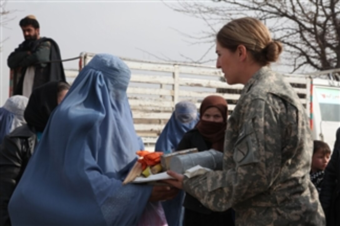 U.S. Army Maj. Bobbie Mayes (right), the women’s empowerment coordinator with the Kentucky Agribusiness Development Team, gives an Afghan woman supplies after a two-day beekeeping class at the Director of Agriculture Livestock and Irrigation Compound in Kapisa province, Afghanistan, on Jan. 6, 2011.  