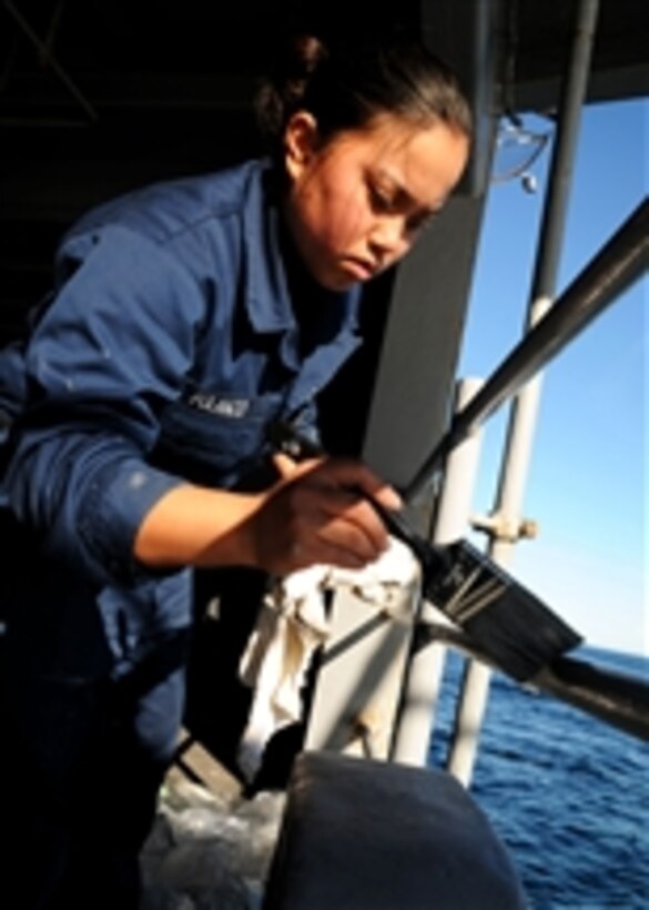 U.S. Navy Seaman Whitney A. Polanco paints handrails on the fantail of the aircraft carrier USS Ronald Reagan (CVN 76) while the ship conducts operations in the Pacific Ocean on Jan. 12, 2011.  