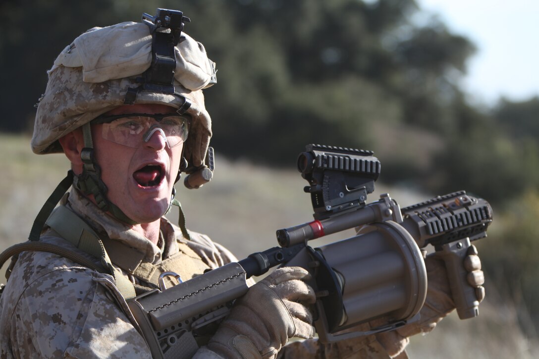 Sgt. Ashford Keena, a rifleman with Alpha Company, 1st Battalion, 23rd Marine Regiment, yells through the sound of rifles and rockets to his squad that he is going to reload his M32 grenade launcher at Camp Pendleton’s Range 600, Jan. 14. The training took place as part of the Houston-based infantry battalion’s intermediate location pre-deployment training. The battalion is currently scheduled to deploy to Afghanistan sometime next month.::r::::n::::r::::n::::r::::n::