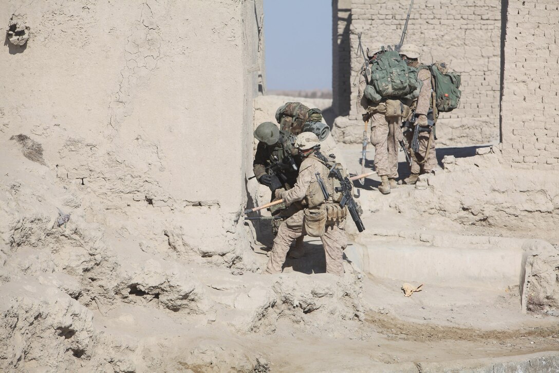 A Marine and Afghan soldier prepare to clear a building in the Durzay bazaar. Marines of Echo Company, 2nd Battalion, 1st Marine Regiment and Afghan soldiers of 1st Kandak, 2nd Brigade, 215th Corps conducted a three-day clearing operation in Durzay starting Jan. 14.