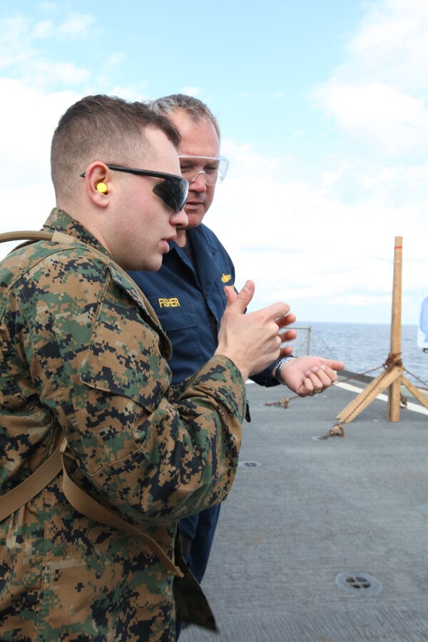 Lance Cpl. Kyle R. Middaugh, a marksmanship coach with Security Task Force Southern Partnership Station 2011, teaches weapons strategies to Sailors aboard Dock landing ship USS Gunston Hall during a weapons qualification course for the on the flight deck of the ship, Jan. 15. Marines and Sailors aboard the ship head to Central and South America in support of Amphibious Southern Partnership Station 2011 which will provide the opportunity for joint exchanges between partner nations.