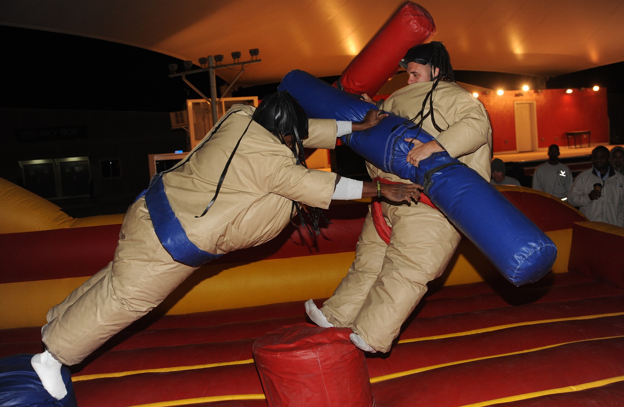 Staff Sgt. Deitrich Arnette pushes Senior Airman Joshua Beacom off the pedestal during a sumo jousting competition, at the Memorial Plaza Jan. 13.  (U.S. Air Force photo/Staff Sergeant Liliana Moreno) (RELEASED)                             