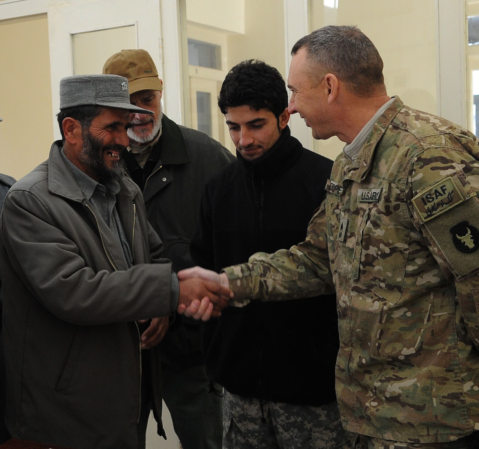 Paryan Afghan National Police trainer Lt. Col. Mohammad Yaseen shakes hands with U.S. Army Master Sgt. Todd Eipperle, senior non-commissioned officer in charge of Task Force Red Bulls Embedded Training Team in Panjshir, and Marshalltown, Iowa, native, after police values and ethics training in Paryan District Jan. 9. More than 15 Afghan National Police members attended the first of 16 classes, taught by Colonel Yaseen. The class is being taught to promote awareness of ethical behavior and how it impacts law enforcement. (U.S. Air Force photo by Senior Airman Amber Ashcraft)