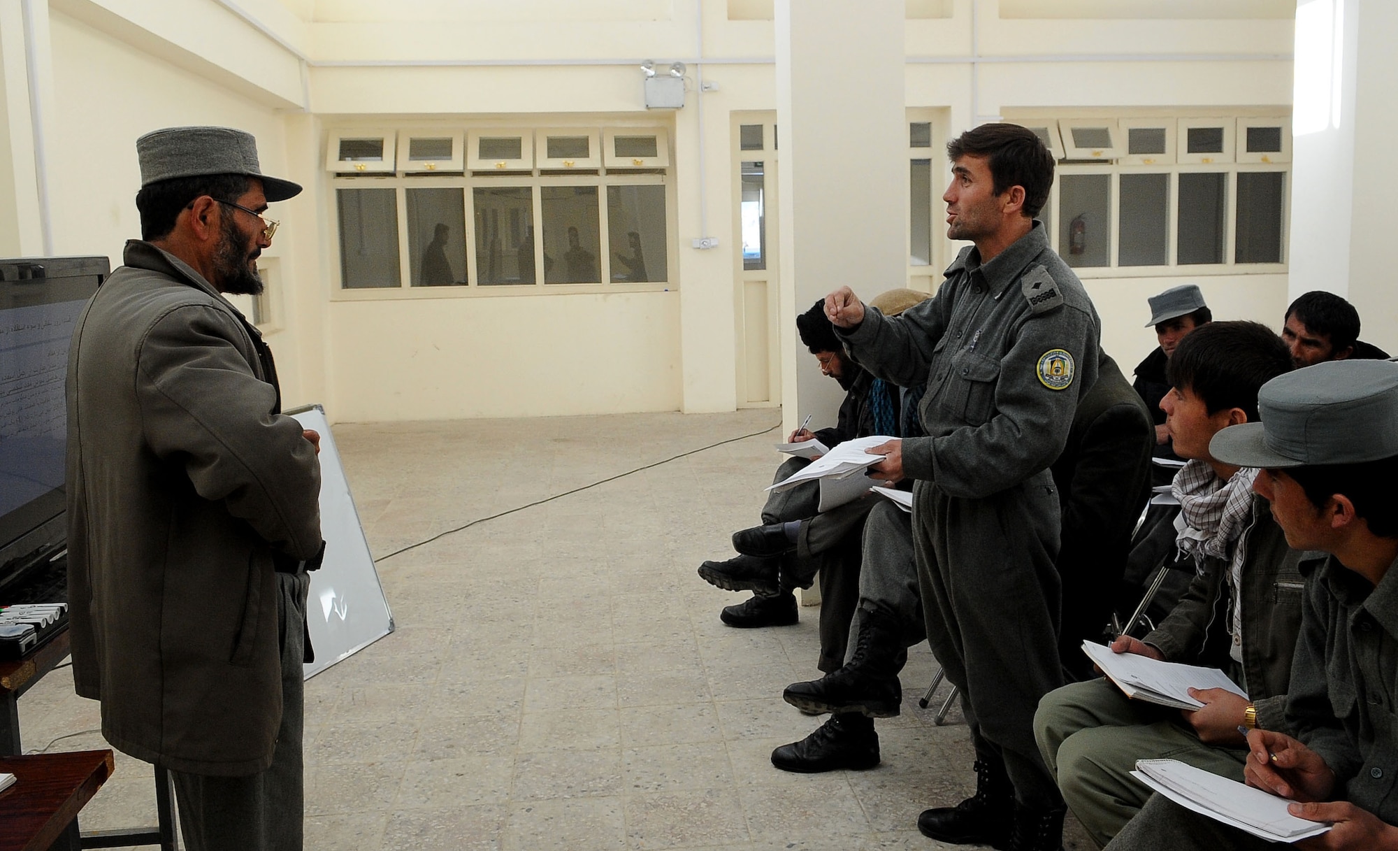 An Afghan National Police officer asks a question during police values and ethics training in Paryan District, Jan. 9. More than 15 ANP members attended the first of 16 classes, taught by the Paryan District ANP trainer. The class is being taught to promote awareness of ethical behavior and how it impacts law enforcement. (U.S. Air Force photo by Senior Airman Amber Ashcraft)