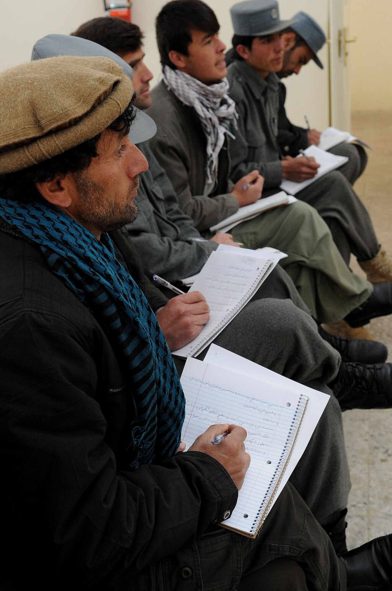 Afghan National Police take notes during their police values and ethics training in Paryan District Jan. 9. More than 15 ANP members attended the first of 16 classes, taught by the Paryan District ANP trainer. The class is being taught to promote awareness of ethical behavior and how it impacts law enforcement. (U.S. Air Force photo by Senior Airman Amber Ashcraft)