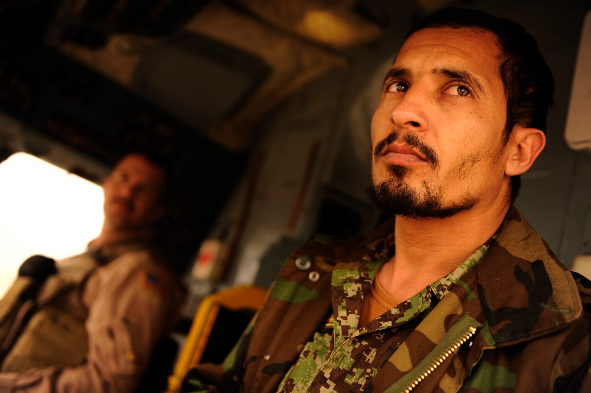 Afghan Air Force 1st Lt. Ehsanullah waits to take off aboard an Mi-17 helicopter with his instructor, U.S. Air Force Maj. Drew Grigson, 444th Air Expeditionary Advisory Squadron, at Shindand Air Base, Afghanistan, Jan 10, 2011.  Shindand AB hosts a pilot training program taught by U.S Air Force Airmen from the 444th AEAS.  (U.S. Air Force Photo/Staff Sgt. Eric Harris) (RELEASED)