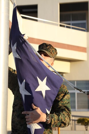Lance Cpl. Gage Thompson, a station military police officer, hooks the American flag up to the rope preparing it to be raised in front of Building One during morning colors here Jan 16. The military police officers raise and lower the flag on a daily basis during morning colors at 8 a.m. and evening colors at sunset.