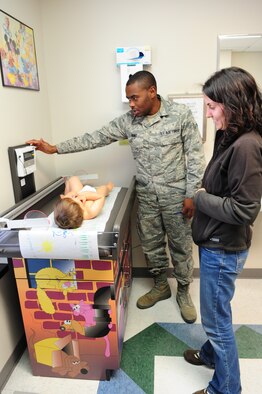 MOODY AIR FORCE BASE, Ga. -- Airman 1st Class Kerji Hunt, 23rd Medical Group aerospace medicine technician, takes the weight of Tyler, son of Capt.  Edward Wineland and wife Tamara, during a baby wellness checkup. The doctor will be looking to see whether the baby is gaining enough weight for his age. (U.S. Air Force photo/Senior Airman Stephanie Mancha)(RELEASED)