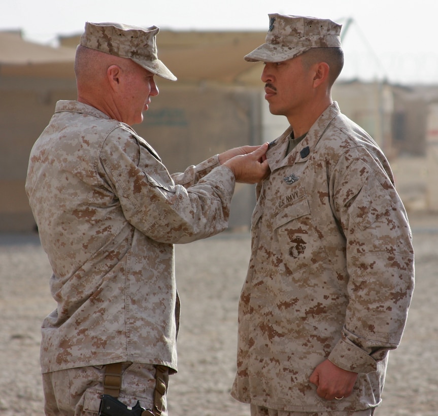 Petty Officer 1st Class Paul Gomez, command master chief executive assistant, 1st Marine Logistics Group (Forward), stands at attention as Brig. Gen. Charles L. Hudson, commanding general of 1st MLG (FWD), promotes him to his current rank during a ceremony at Camp Leatherneck, Afghanistan, Jan. 17. Gomez, 32, a native of El Paso, Texas, was combat meritoriously promoted to the rank of petty officer first class.