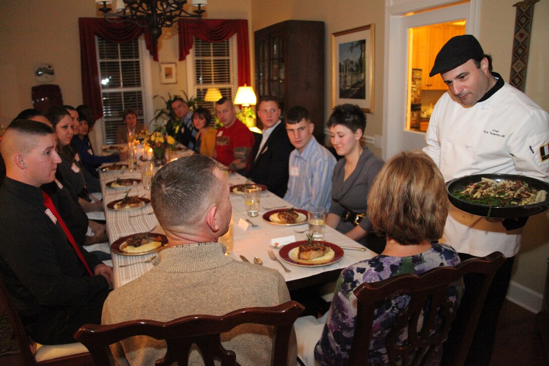 Chef Rick Tarantino, right, offers a serving of white asparagus to Carol Davis, spouse of 2nd Marine Aircraft Wing commanding general, Maj. Gen. Jon M. Davis Jan. 18, during a dinner Davis hosted in his home for eight 2nd MAW Marines, who demonstrated acts of courage in 2010. Tarantino, who regularly appears on the Home Shopping Network, said, “giving back and cooking for the men and women that protect our country is my privilege.”