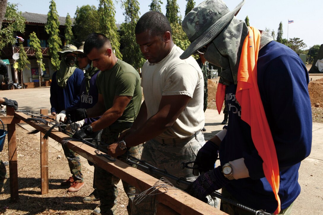Royal Thai Marines with Combat Engineer Battalion and U.S. servicemen with Marine Wing Support Squadron 172, Marine Wing Support Group 17, 1st Marine Aircraft Wing, III Marine Expeditionary Force, assemble rebar cages to be used later in the construction of a classroom during a civil affairs project in support of Exercise Cobra Gold 2011 at Ban Muang Rae School, Rayong province, Kingdom of Thailand Jan. 18. This is one of many engineering projects planned during the exercise.