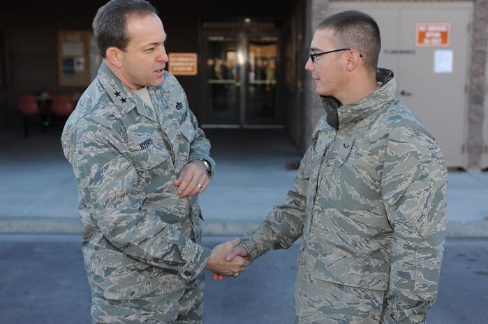 NELLIS AIR FORCE BASE, Nev.-- Maj. Gen. Timothy Byers, the Air Force Civil Engineer, presents a coin to Airman First Class Andrew Perna, 99th Civil Engineer Squadron, Jan. 12. During his visit, the general also gave coins to Capt. Maureen Downen, Master Sgt. Kieran Flynn, Tech. Sgt. Stephen Styles and Glen Taylor. (U.S. Air Force photo)