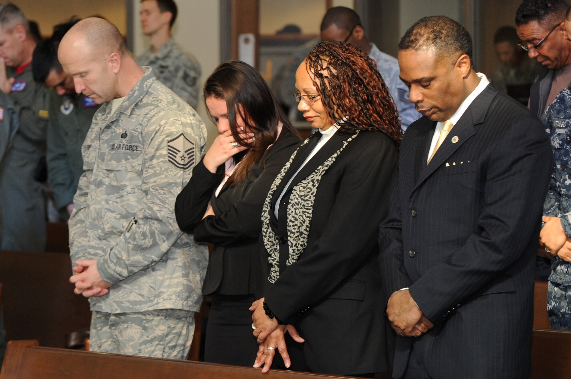 BUCKLEY AIR FORCE BASE, Colo.-- Members of team Buckley bow their heads for a brief benediction at the Martin Luther King Jr. Holiday event, Jan 14, 2011. Members of all races, religious backgrounds and age gathered together in remembrance of  the legendary man who had a dream. (U.S. Air Force photo by Airman Manisha Vasquez) 