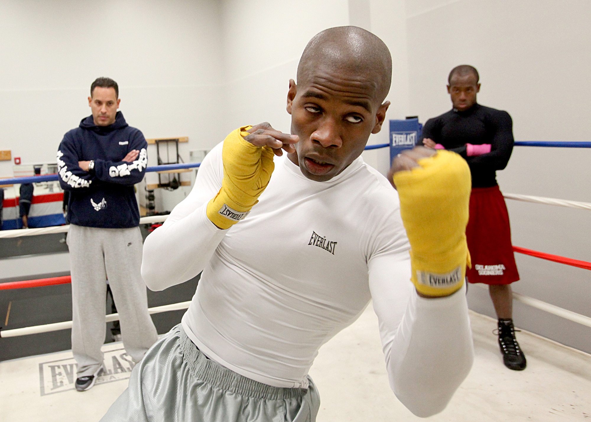 Air Force camp boxer Gary Griffin, of Stewart Air National Guard Base, N.Y., throws an uppercut Jan. 10, 2011, while boxing coach Steven Franco (left), and Daniel Logan (right), from Tinker Air Force Base, Okla., watch. (U.S. Air Force photo/Robbin Cresswell)