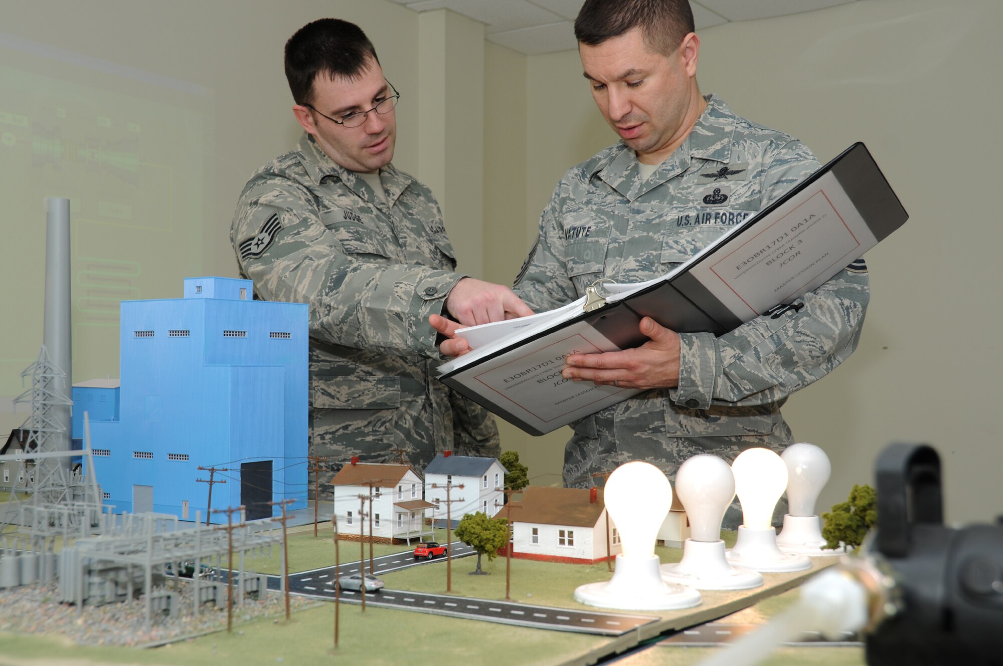 Sergeant Judge, left, and Sergeant Matute do a final equipment check on the industrial control systems equipment to ensure results of their first ICS exercise were correct.  (U.S. Air Force photo by Kemberly Groue)
