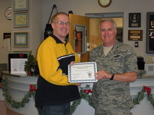 NELLIS AIR FORCE BASE, Nev.-- Col. Kevin Fox, 99th Mission Support Group commander, presents a coin and certificate of appreciation to Tech. Sgt. Steven Shoemake Nov. 17 at the Youth Center. Sergeant Shoemake was named the November Volunteer of the Month for Nellis by the base Youth Programs for his extensive work with the Robotics program. The Airman and Family Readiness Center organizes the volunteer program for the base, and anyone interested in volunteering in the local community should call the center at 652-3327. (Courtesy photo)