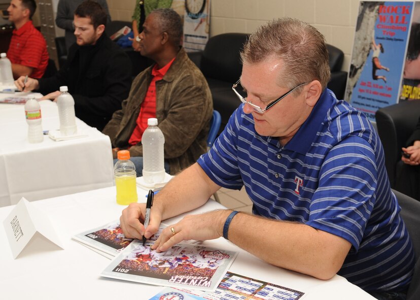 Dave Barnett, Texas Rangers broadcaster, autographs, at the Barksdale Fitness Center, located on Barksdale Air Force Base, La., Jan. 18. Members of the 2010 Major League Baseball American League Championship team came to Barksdale to showcase their William Harridge Award trophy, sign posters and baseballs and to meet Team Barksdale Airmen. (U.S. Air Force photo/Airman 1st Class Sean Martin)(Released)