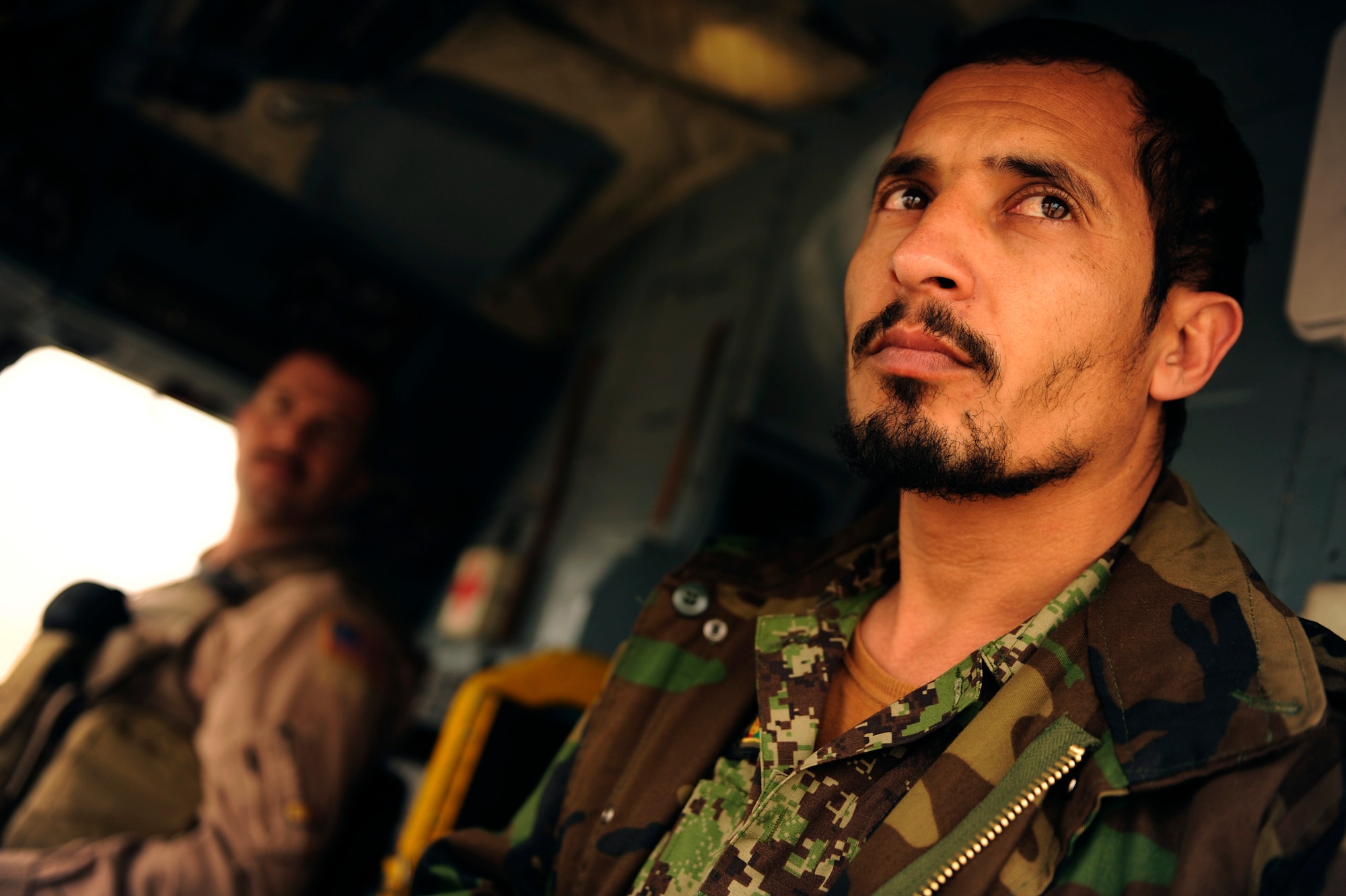 Afghan air force 1st Lt. Ehsanullah waits to take off aboard an Mi-17 with his instructor, Maj. Drew Grigson, Jan. 10, 2011, at Shindand Air Base, Afghanistan. Shindand AB officials host a pilot training program taught by Airmen from the 444th AEAS. Major Grigson is from the 444th Air Expeditionary Advisory Squadron. (U.S. Air Force photo/Staff Sgt. Eric Harris) 