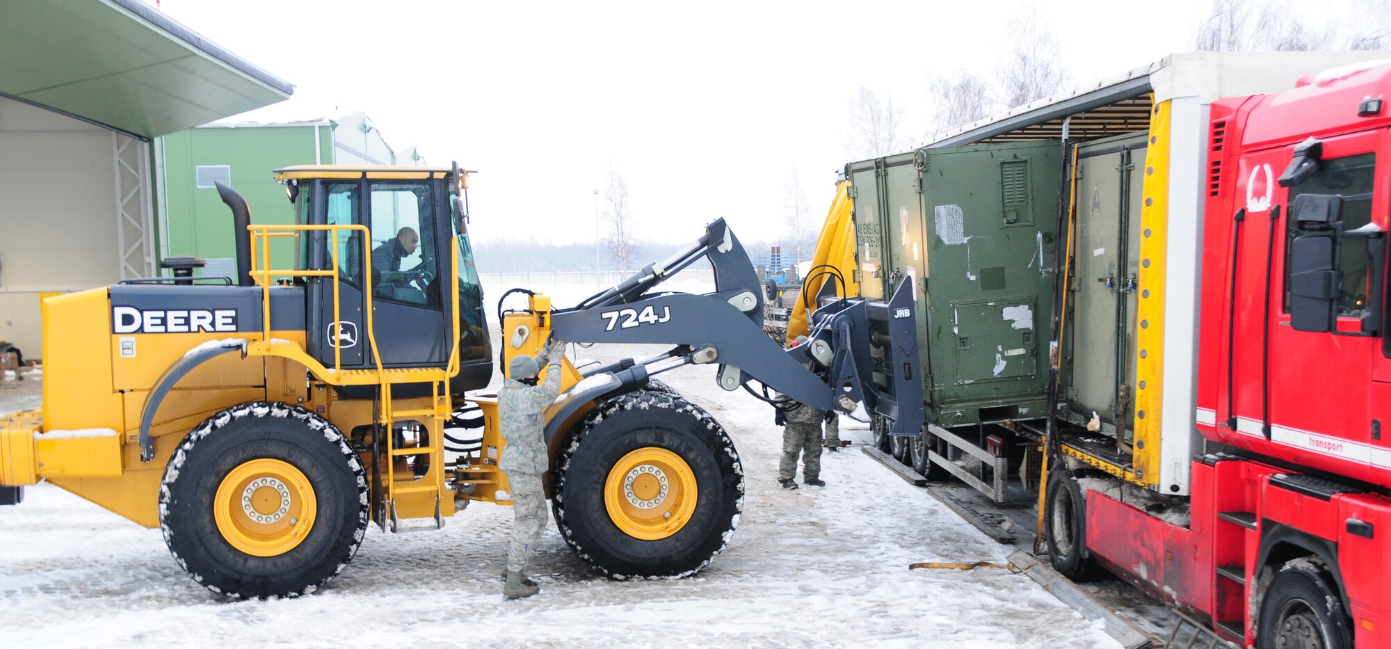 Senior Airman Grant Cairel uses a forklift to load a container onto a trailer while being guided by Senior Airman Scott Knight Jan. 7, 2011, at Lithuania Air Base, Lithuania. Airman Cairel is a transportation management journeyman with the 493rd Expeditionary Fighter Squadron Redeployment Action Team. Airman Knight is an air transportation journeyman with the 493rd EFS RAT. (U.S. Air Force photo/Staff Sgt. Stephen Linch) 