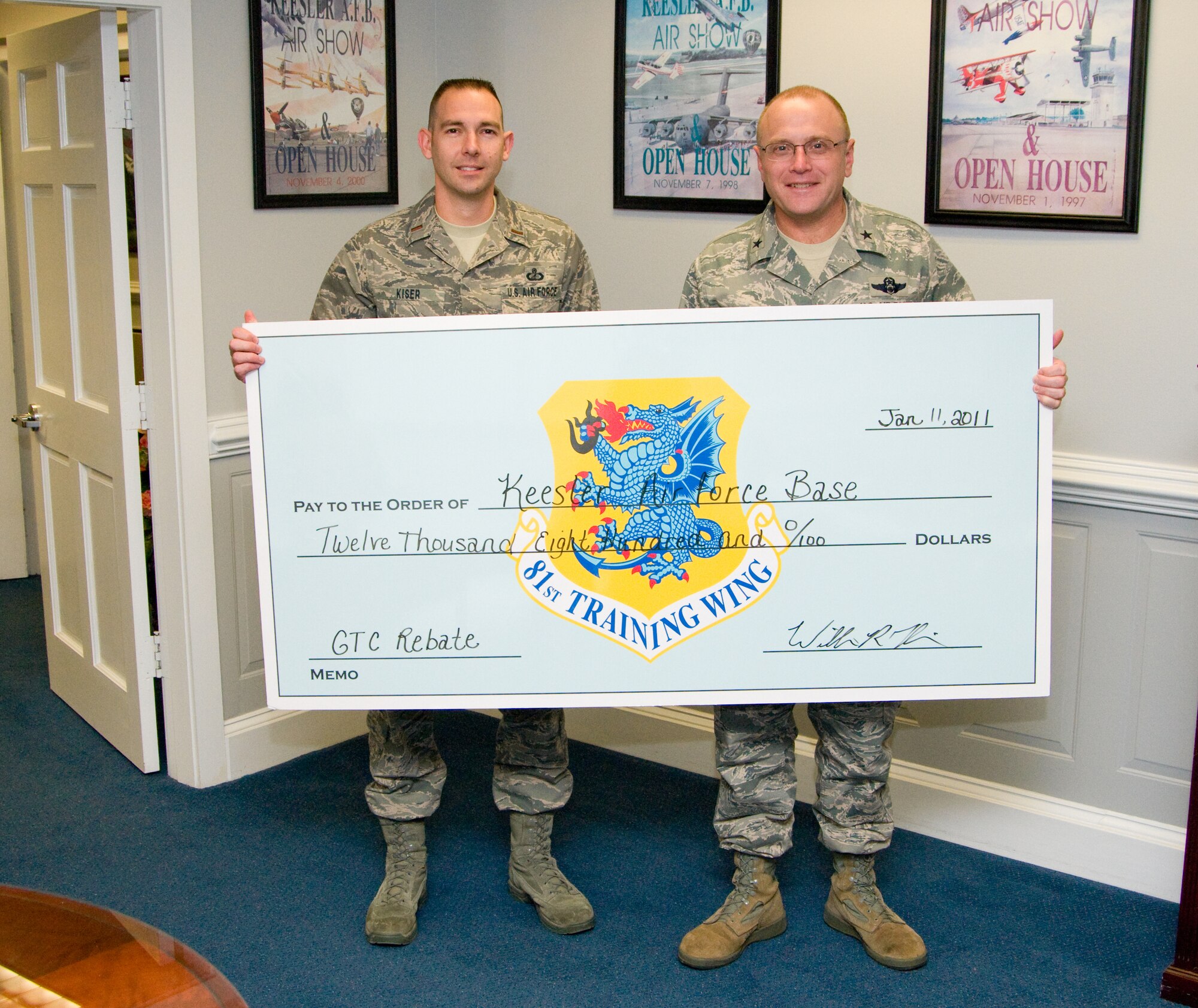 Kiser, left, and General Mueller display a check representing Keesler's rebate Jan. 11 at wing headquarters.  (U.S. Air Force photo by Adam Bond)
