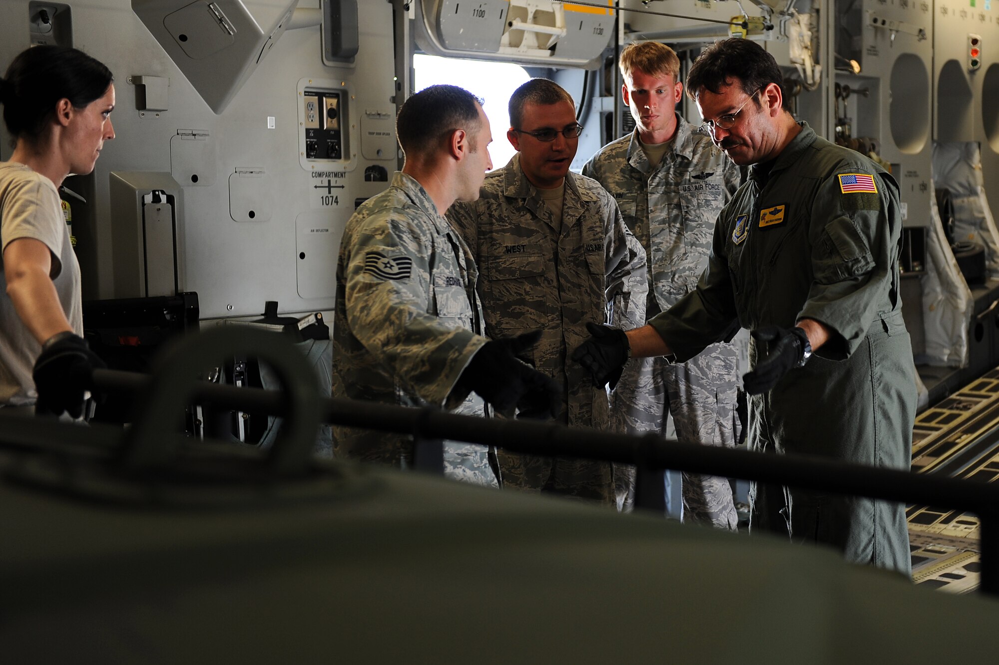 Master Sgt. Brian Chewning, 535th Airlift Squadron loadmaster, reviews load requirements with 36th Contingency Response Group personnel before loading a helicopter at Andersen Air Force Base, Guam, Jan. 13.  Airmen and Sailors from the 36th Contingency Response Group practiced loading a helicopter and a tactical vehicle onto a C-17 Globemaster III from Joint Base Pearl Harbor-Hickam, Hawaii. The Aircrew from the 535th AS maximized their airdrop and training opportunities while visiting Guam by airdropping static line and high altitude low opening paratroopers, nine training pallets and a boat. (U.S. Air Force photo/Staff Sgt. Mike Meares) 