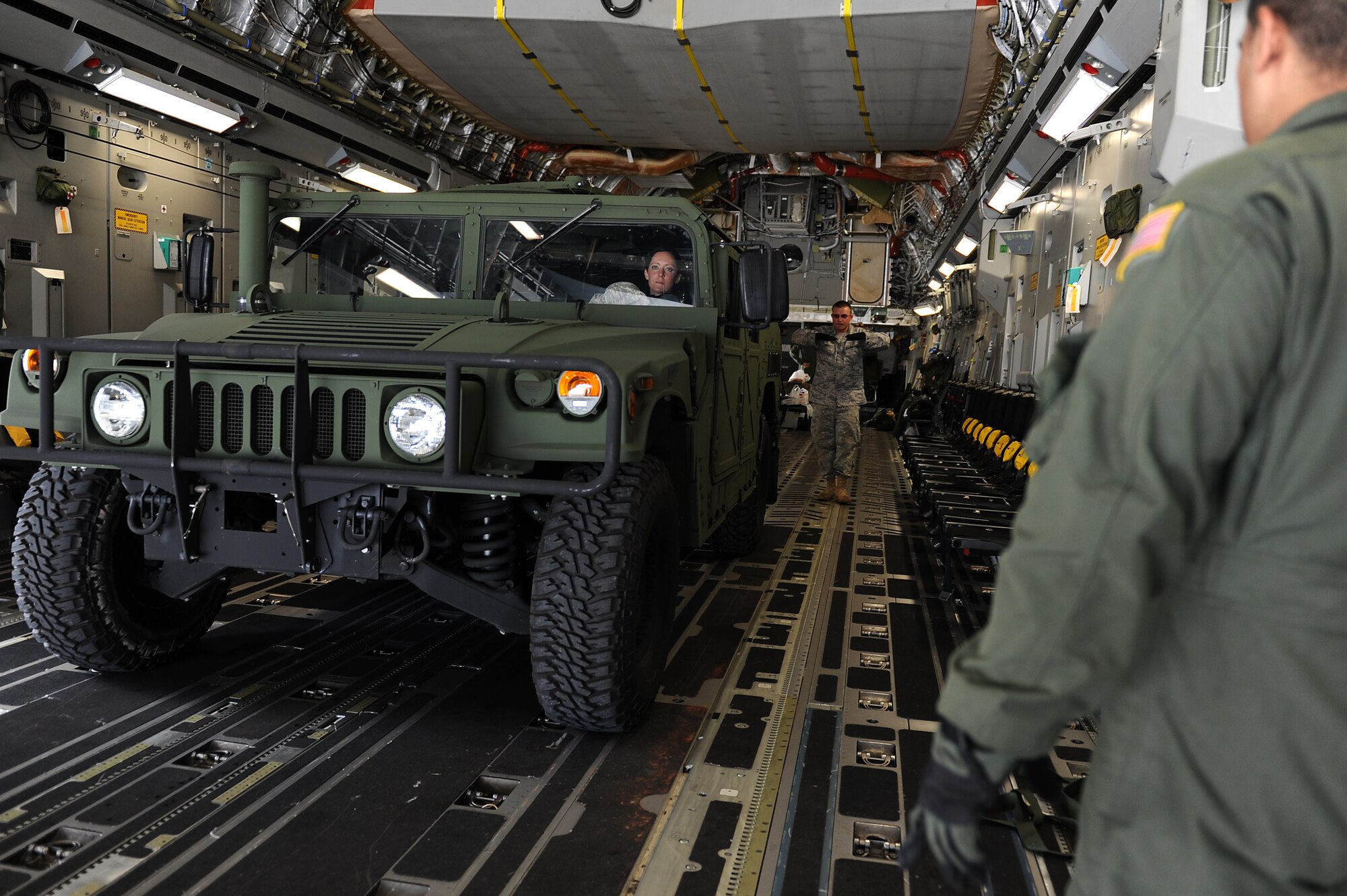 Staff Sgt. Danny Hollister, 535th Airlift Squadron loadmaster, guides an airman from the 36th Contingency Response Group while practicing loading a tactical vehicle onto a C-17 Globemaster III from Joint Base Pearl Harbor-Hickam, Hawaii. The Aircrew from the 535th AS maximized their airdrop and training opportunities while visiting Guam by airdropping static line and high altitude low opening paratroopers, nine training pallets and a boat. (U.S. Air Force photo/Staff Sgt. Mike Meares)