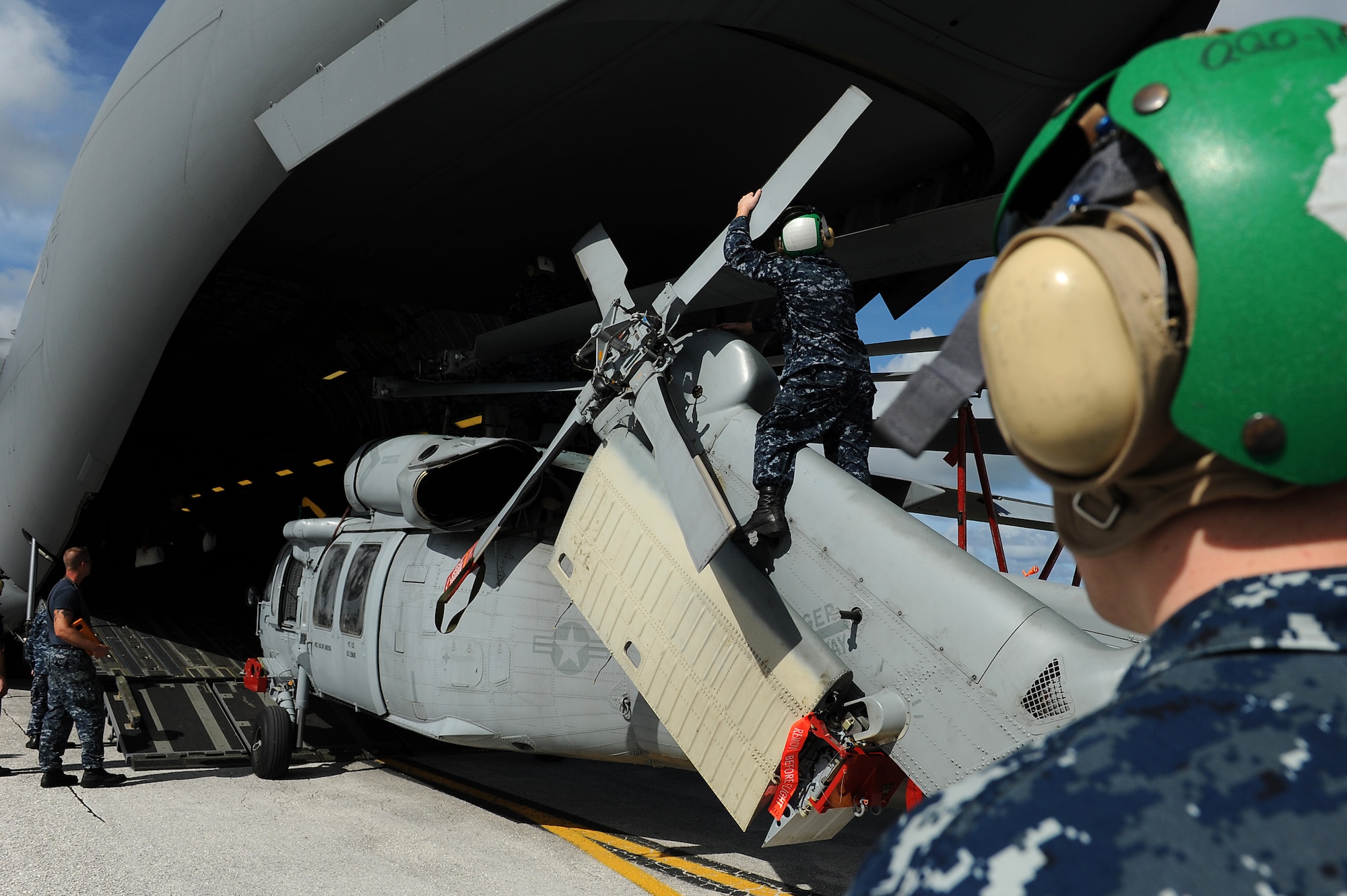 Airmen and Sailors from the 36th Contingency Response Group, Andersen Air Force Base, Guam, practice loading a helicopter onto a C-17 Globemaster III from Joint Base Pearl Harbor-Hickam, Hawaii, Jan. 13. The Aircrew from the 535th Airlift Squadron maximized their airdrop and training opportunities while visiting Guam by dropping airdropping paratroopers, nine training pallets and a boat. (U.S. Air Force photo/Staff Sgt. Mike Meares) 