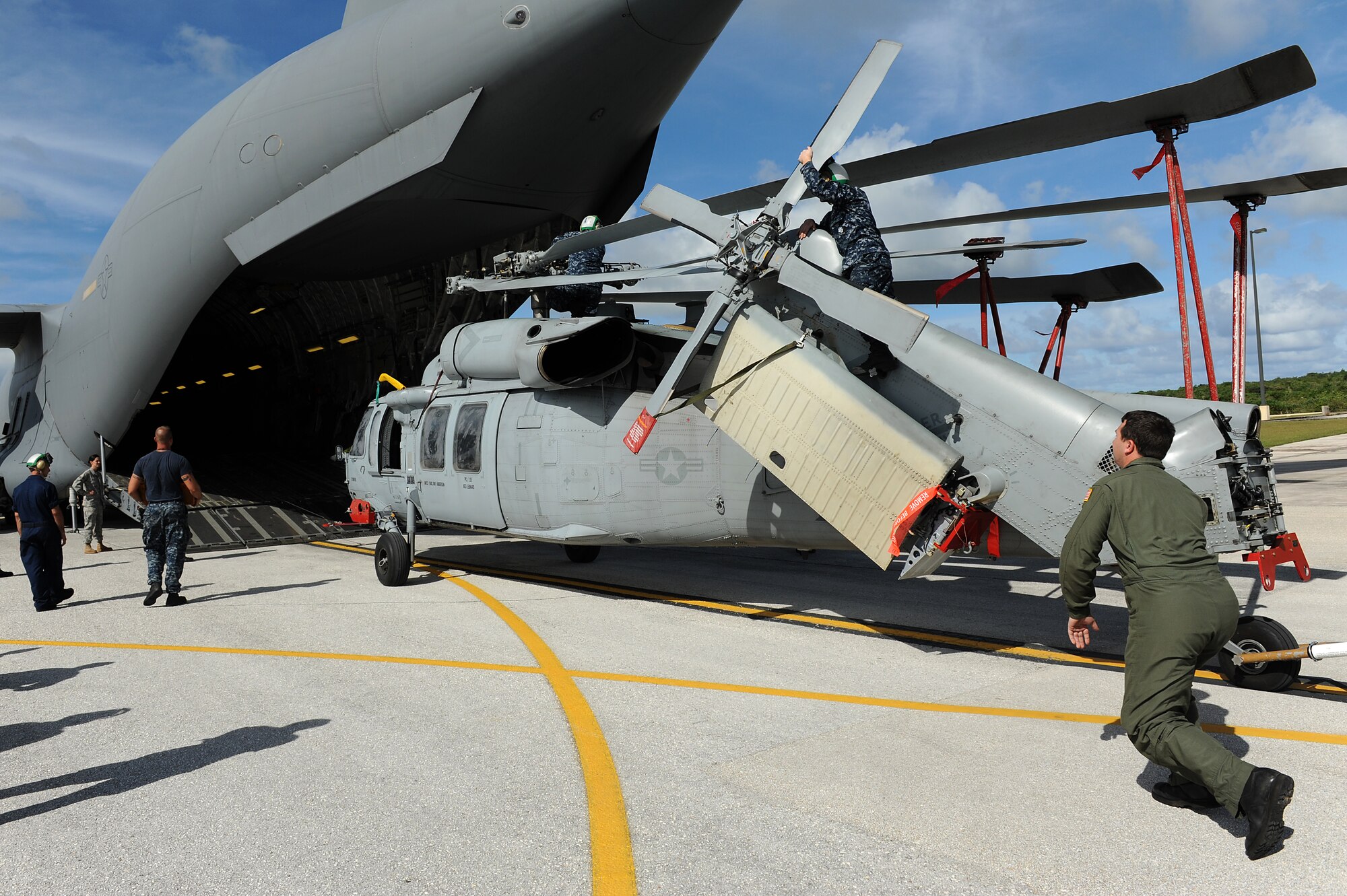 Airmen and Sailors from the 36th Contingency Response Group, Andersen Air Force Base, Guam, practice loading a helicopter onto a C-17 Globemaster III from Joint Base Pearl Harbor-Hickam, Hawaii, Jan. 13. The Aircrew from the 535th Airlift Squadron maximized their airdrop and training opportunities while visiting Guam by dropping airdropping paratroopers, nine training pallets and a boat. (U.S. Air Force photo/Staff Sgt. Mike Meares) 