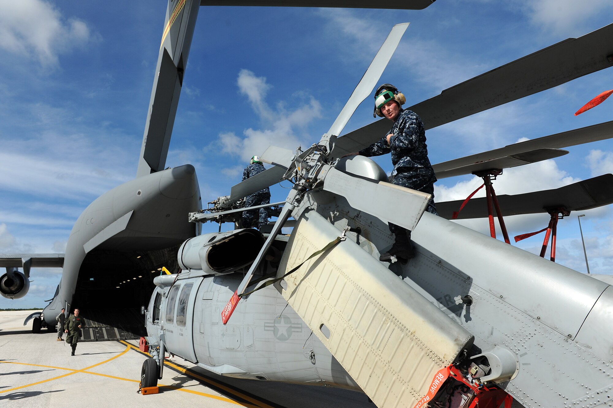 Airmen and Sailors from the 36th Contingency Response Group, Andersen Air Force Base, Guam, practice loading a helicopter onto a C-17 Globemaster III from Joint Base Pearl Harbor-Hickam, Hawaii, Jan. 13. The Aircrew from the 535th Airlift Squadron maximized their airdrop and training opportunities while visiting Guam by dropping airdropping paratroopers, nine training pallets and a boat. (U.S. Air Force photo/Staff Sgt. Mike Meares) 