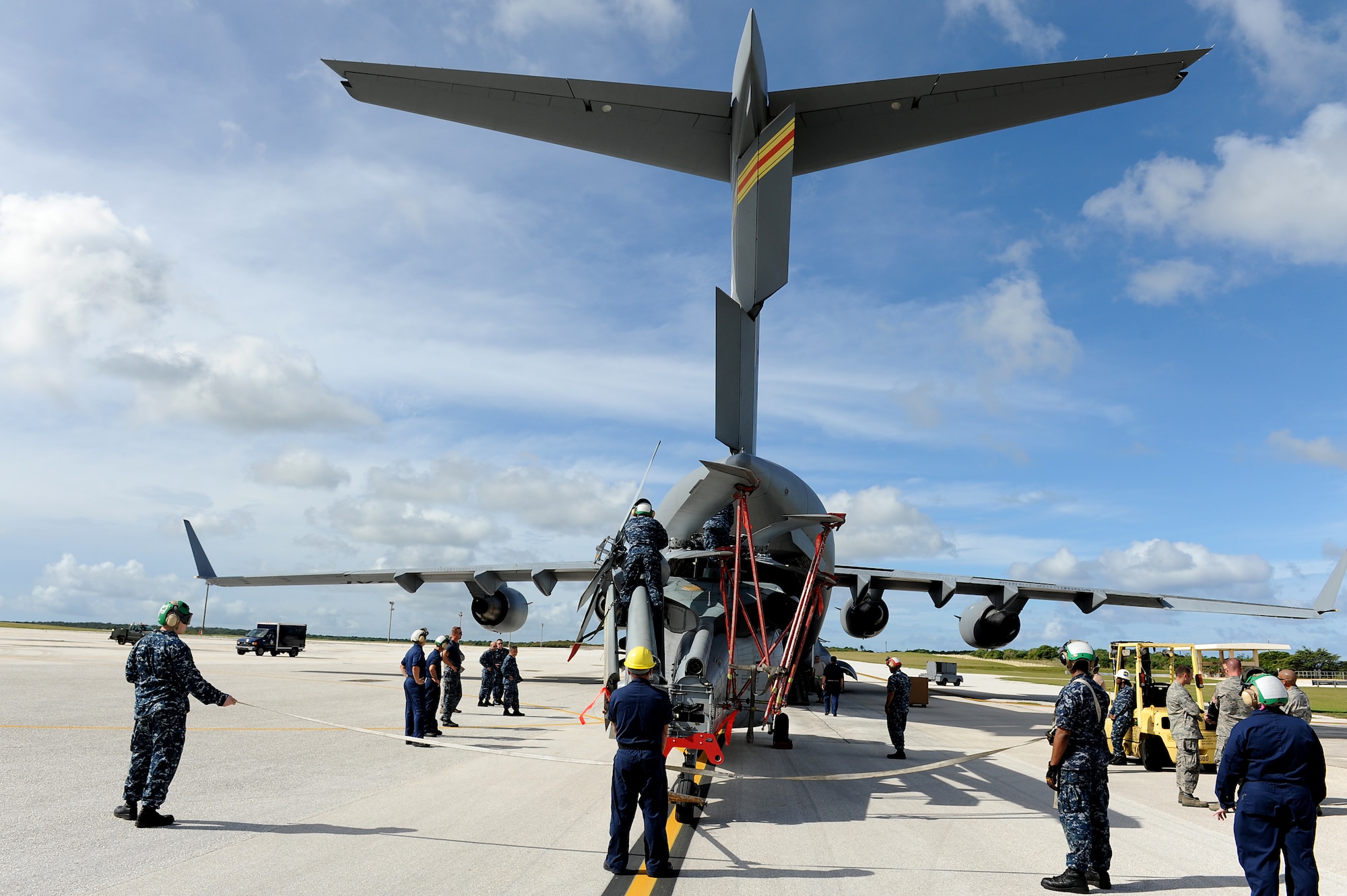 Airmen and Sailors from the 36th Contingency Response Group, Andersen Air Force Base, Guam, practice loading a helicopter onto a C-17 Globemaster III from Joint Base Pearl Harbor-Hickam, Hawaii, Jan. 13. The Aircrew from the 535th Airlift Squadron maximized their airdrop and training opportunities while visiting Guam by dropping airdropping paratroopers, nine training pallets and a boat. (U.S. Air Force photo/Staff Sgt. Mike Meares) 