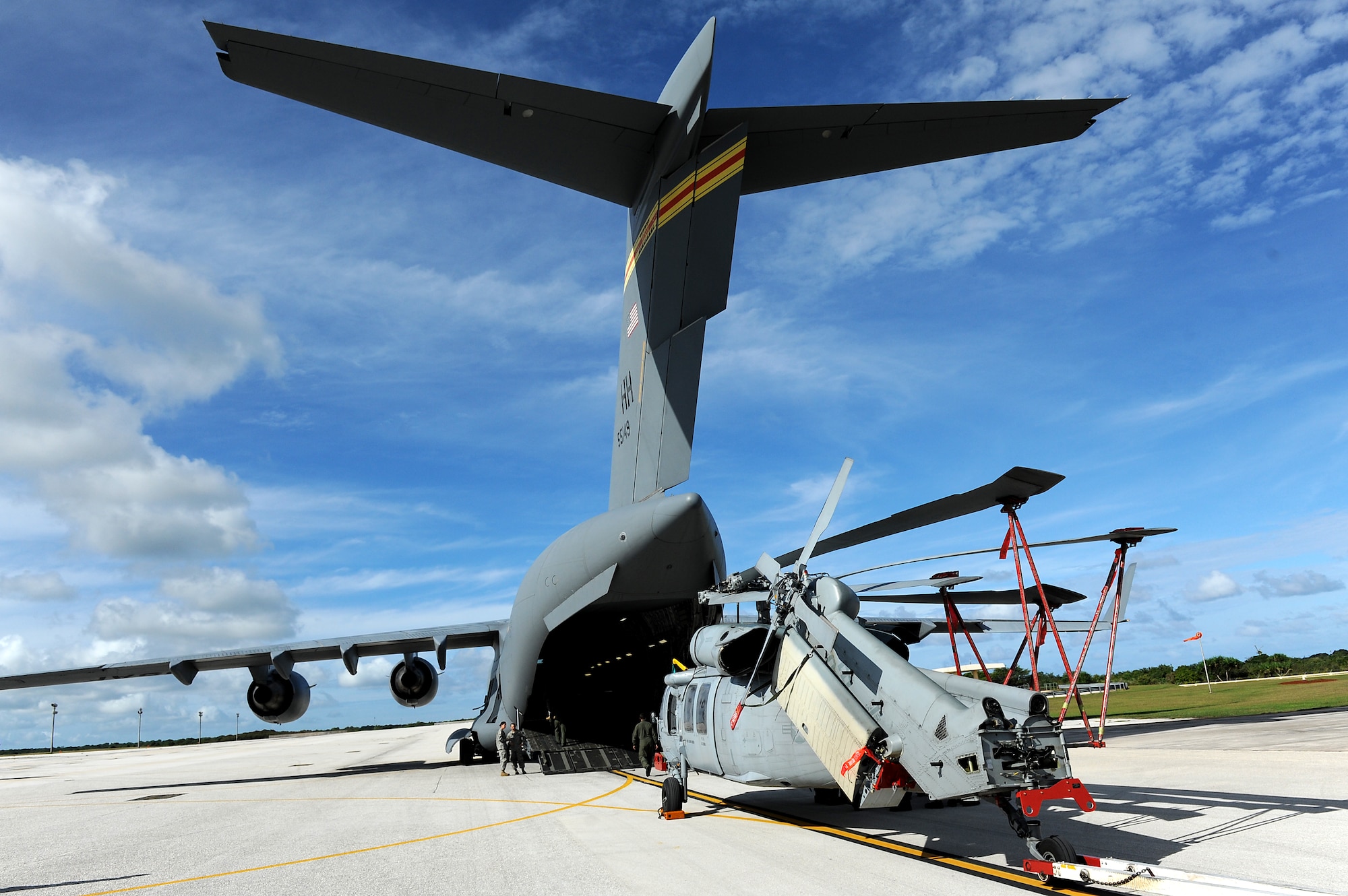 Airmen and Sailors from the 36th Contingency Response Group, Andersen Air Force Base, Guam, practice loading a helicopter onto a C-17 Globemaster III from Joint Base Pearl Harbor-Hickam, Hawaii, Jan. 13. The Aircrew from the 535th Airlift Squadron maximized their airdrop and training opportunities while visiting Guam by dropping airdropping paratroopers, nine training pallets and a boat. (U.S. Air Force photo/Staff Sgt. Mike Meares) 