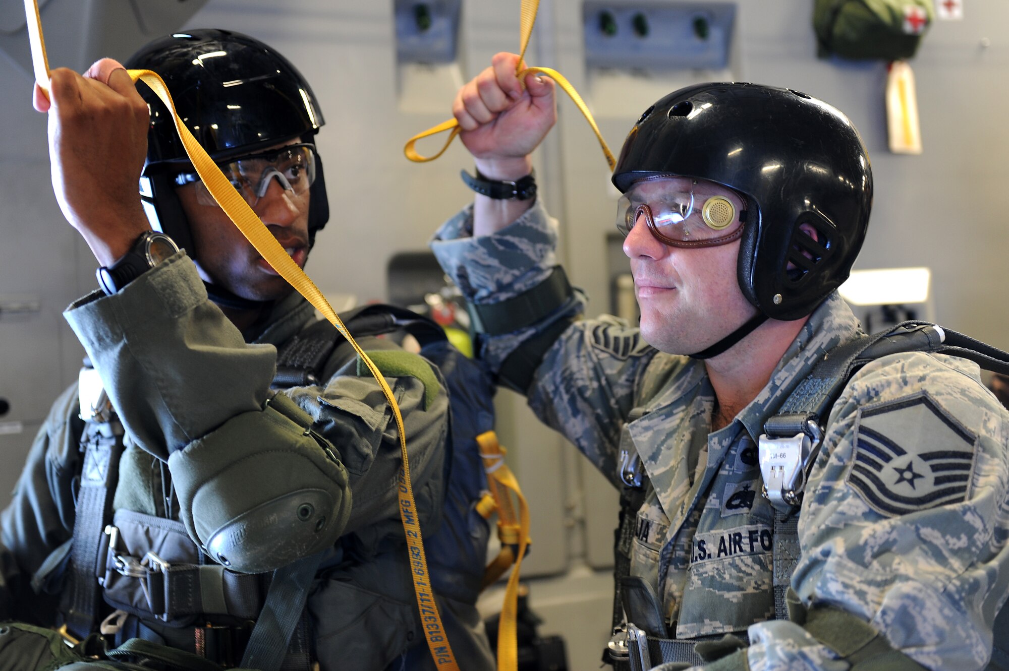 Master Sgt. Justin Papalia and Staff Sgt. Devant Jones, 36th Contingency Response Group jump masters, prepare to send 15 Airmen out the troop door of a Joint Base Pearl Harbor-Hickam, Hawaii C-17 Globemaster III Jan. 13.  Hickam aircrew provided four static line jumps for the 36th CRG?s proficiency training over two separate days. (U.S. Air Force photo/Staff Sgt. Mike Meares)