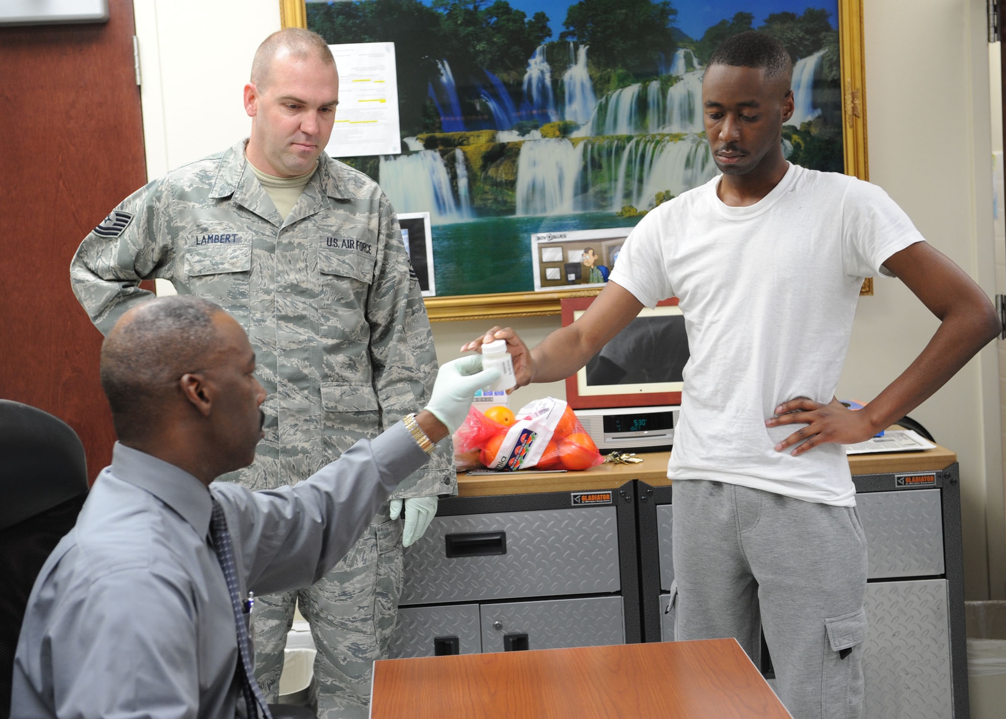 DYESS AIR FORCE BASE, Texas—Airman 1st Class Keenan Watson, 7th Comptroller Squadron, hands in his urine sample Jan. 18 to Theodis Talbert, 7th Medical Operations Squadron, at the medical clinic here. Col. David Béen, 7th Bomb Wing commander, directed a morale, health and welfare inspection in an effort to enforce zero tolerance for misconduct or misbehavior. During this inspection, dorm residents were taken for drug testing while their rooms were inspected by first sergeants and military working dogs for drugs, weapons and other unauthorized items. (U.S Air Force photo/ Airman 1st Class Shannon Hall) 