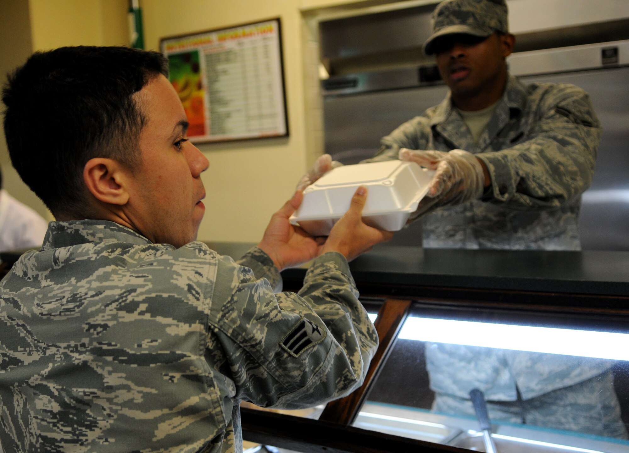 Airman 1st Class Julian Royal, a food service apprentice with the 18th Force Support Squadron, gives a midnight meal to Senior Airman Efrain Vazquez, an electrical and environmental systems technician with the 18th Component Maintenance Squadron at the Marshall Dining Facility at Kadena Air Base, Jan. 18. Many more Airman are eating late night chow while participating in Beverly High 11-02. (U.S. Air Force photo/Airman 1st Class Jarvie Z. Wallace)