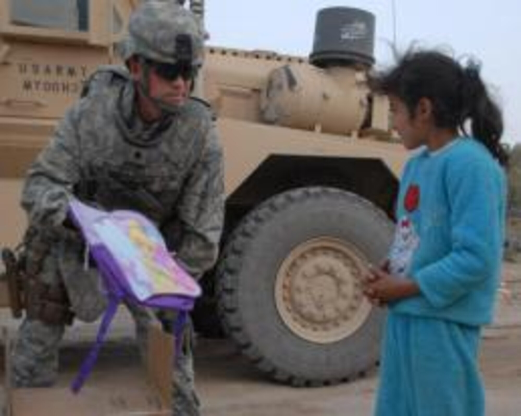 U.S. Air Force Lt. Col. Tom Walsh, Echelon Above Division-Advise and Train senior advisor and Benbrook, Texas, native, hands a “tinkerbell” backpack to a local Iraqi girl, Dec. 16, at Ur Elementary School near Tallil Air Base, Iraq. Walsh is deployed from the Pentagon. (Courtesy Photo)


