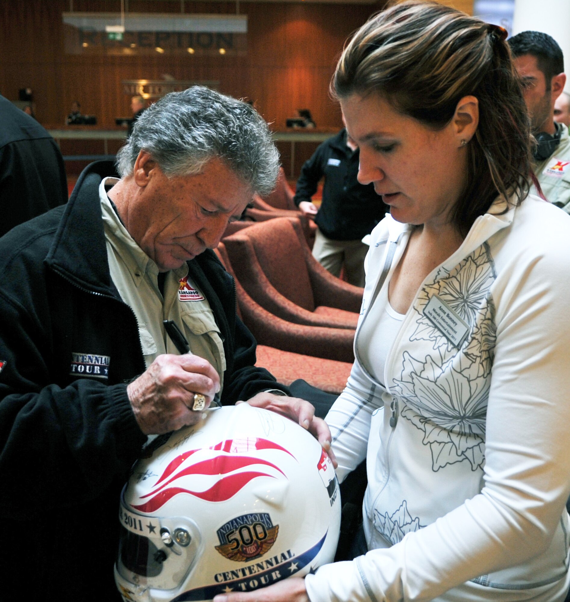 Mario Andretti, an Indy 500, Daytona 500, and Formula 1 champion, autographs a helmet during the Indy 500 Centennial Tour, Ramstein Air Base, Germany, Jan. 14, 2011. The Indy 500 Centennial tour brings Indy racing teams to Europe and the Middle East over a 10 day tour to honor and boost morale for service members and their families. (U.S. Air Force photo by Senior Airman Caleb Pierce)