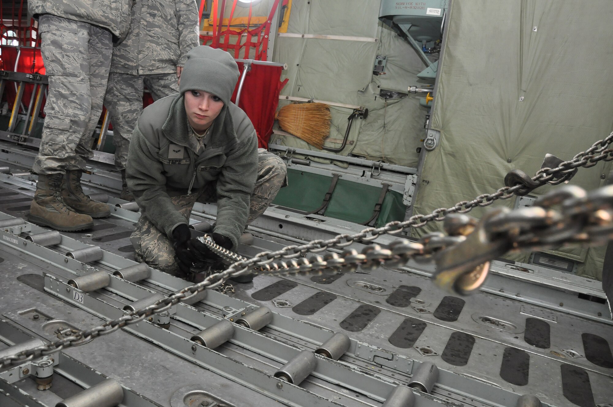 Airmen 1st Class Brandi Tepe, air transportation specialist, 27th Aerial Port Squadron, chains down a Humvee during a simulated aircraft load at the Minneapolis-St. Paul IAP ARS, Minn (Air Force Photo/Tech. Sgt. Bob Sommer)
