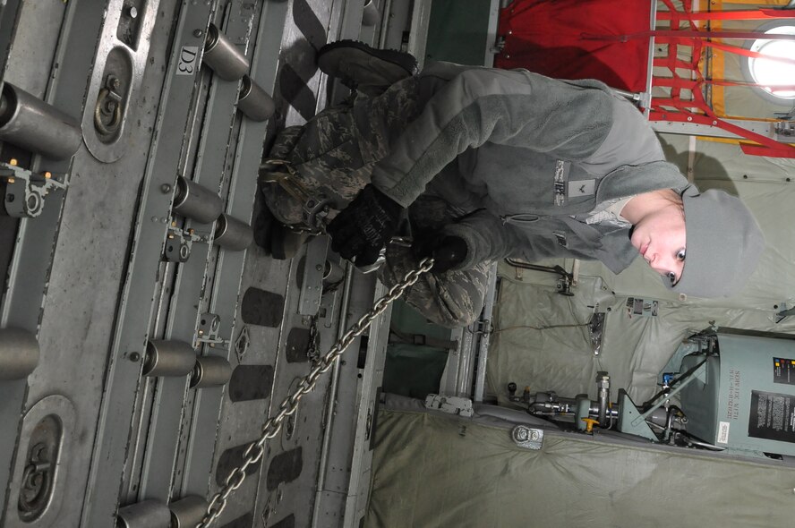 Airmen 1st Class Brandi Tepe, air transportation specialist, 27th Aerial Port Squadron, chains down a Humvee during a simulated aircraft load at the Minneapolis-St. Paul IAP ARS, Minn (Air Force Photo/Tech. Sgt. Bob Sommer)