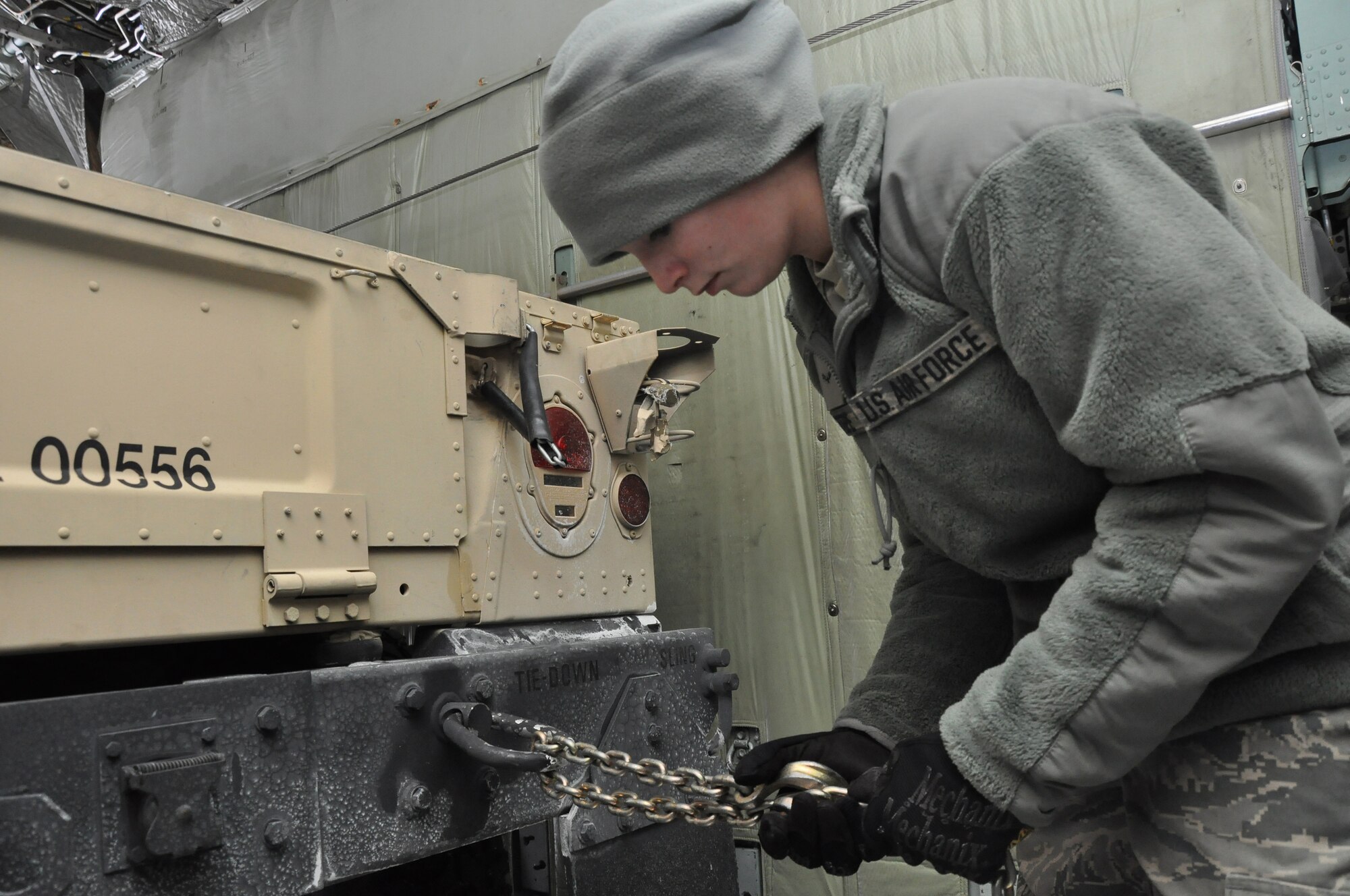 Airmen 1st Class Brandi Tepe, air transportation specialist, 27th Aerial Port Squadron, chains down a humvee during a simulated aircraft load at the Minneapolis-St. Paul IAP ARS, Minn. (Air Force Photo/Tech. Sgt. Bob Sommer)