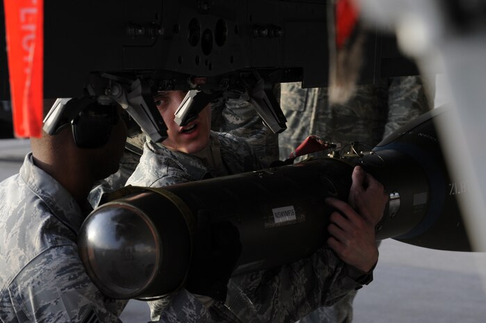 NELLIS AIR FORCE BASE, Nev. -- Airman 1st Class Michael Schena and Staff Sgt. Melvin Marshall, 757th Aircraft Maintenance Squadron aircraft armament systems specialists, prepare to attach a GBU-24 laser-guided bomb to a F-15 Eagle during a weapons load competition on the Nellis flightline Jan. 14. Weapons load competitions are conducted quarterly to keep Airmen sharp and recognize superior performers. Weapons load teams are evaluated for use of the checklist, safety, and overall speed. (U.S. Air Force photo by Airman 1st Class George Goslin)