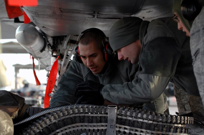 NELLIS AIR FORCE BASE, Nev.-- Staff Sgt. John Castro and Airman 1st Class Josh Stephenson, 757th Aircraft Maintenance Squadron, armament systems specialists, loads M-61A1 20mm rounds in a F-15 Eagle during a weapons load competition on the Nellis flightline Jan. 14. Weapons load competitions are conducted quarterly to keep Airmen sharp and recognize superior performers. Weapons load teams are evaluated for their use of the checklist, safety, and overall speed. (U.S. Air Force photo by Airman 1st Class Matthew Lancaster)