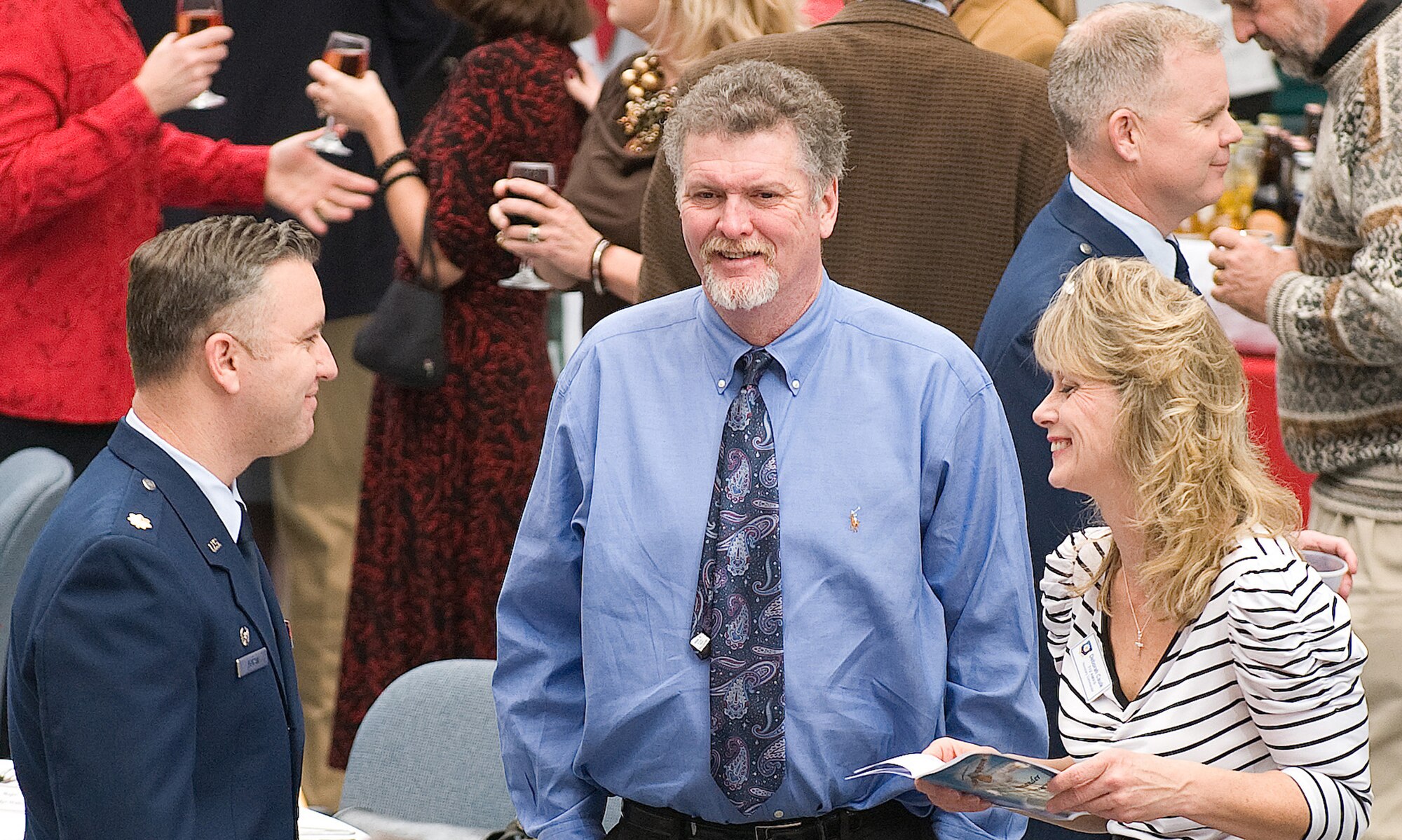 Debra Caulk (right), honorary commander for the 712th Aircraft Maintenance Squadron, her husband Rodney, and Maj. John Foran, 512 AMXS, mingle during social hour at the Dover Air Force Base, Del., 2011 Honorary Commanders Induction Ceremony Jan. 7, 2011.  The induction ceremony is held annually to induct local community leaders as honorary commanders of an organization on base. (U.S. Air Force photo/Jason Minto)